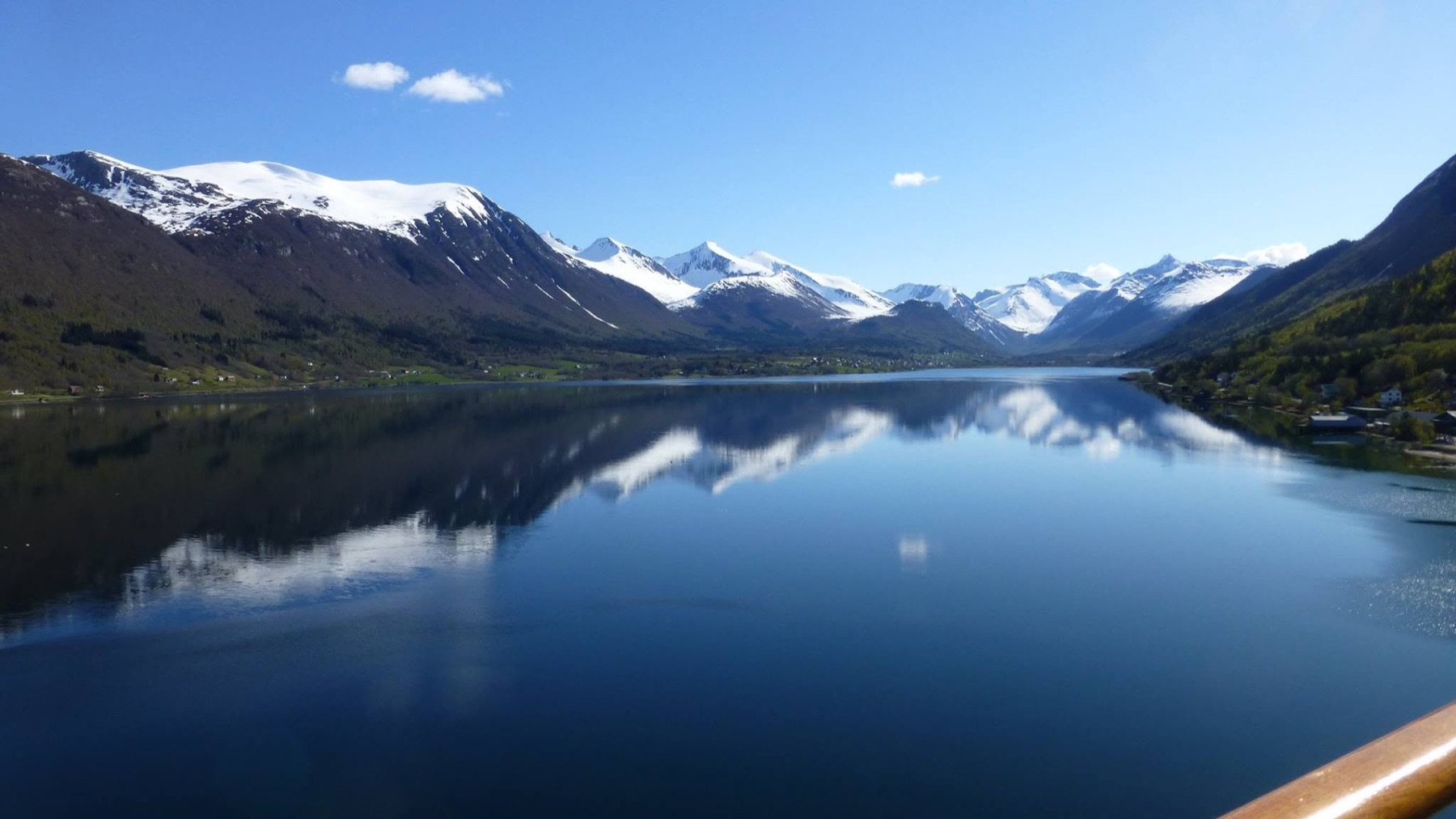 A Norwegian fjord from the deck, mountains reflected in still water
